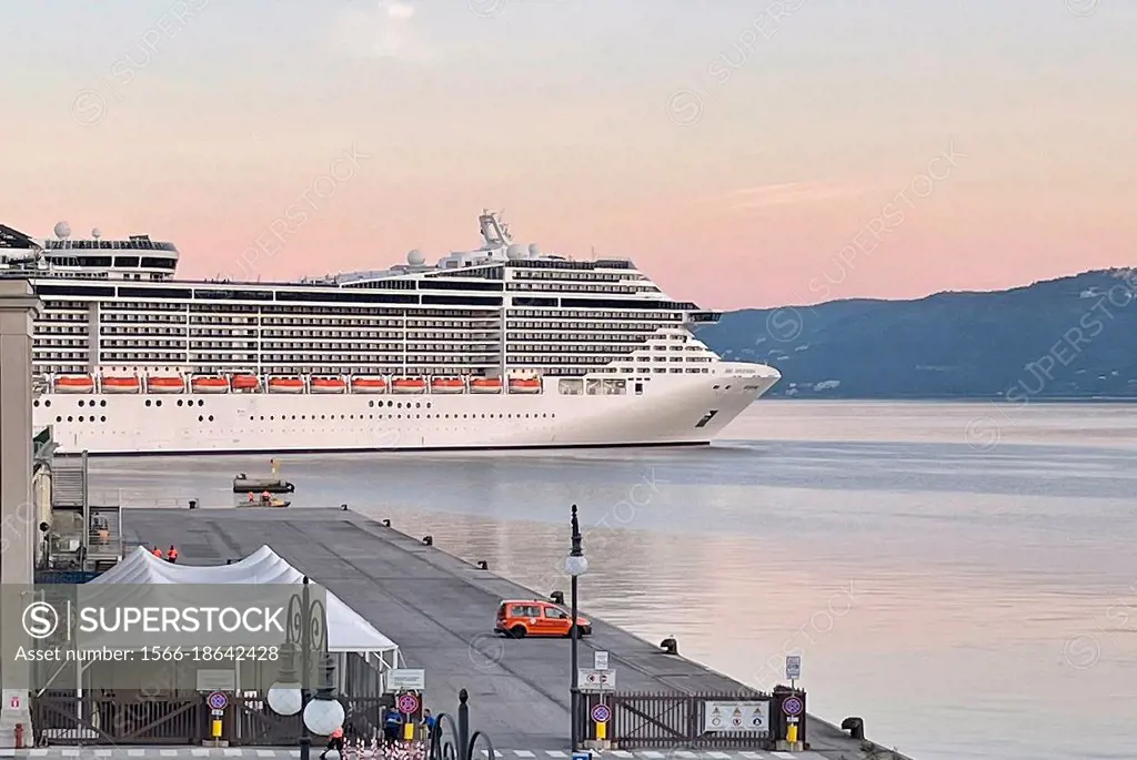 Cruise ship docks in the port of Trieste after sunrise - Italy.