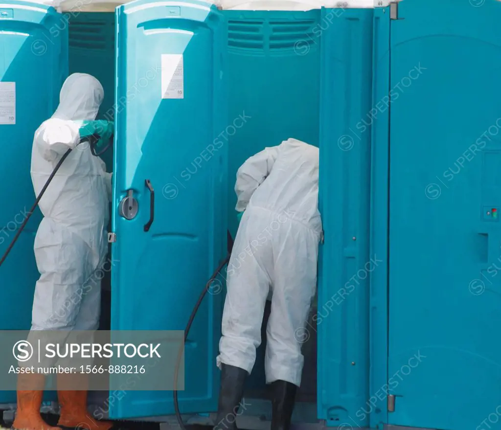 Men emptying and cleaning Portaloo chemical toilets at Las Palmas carnival on Gran Canaria, Canary Islands, Spain