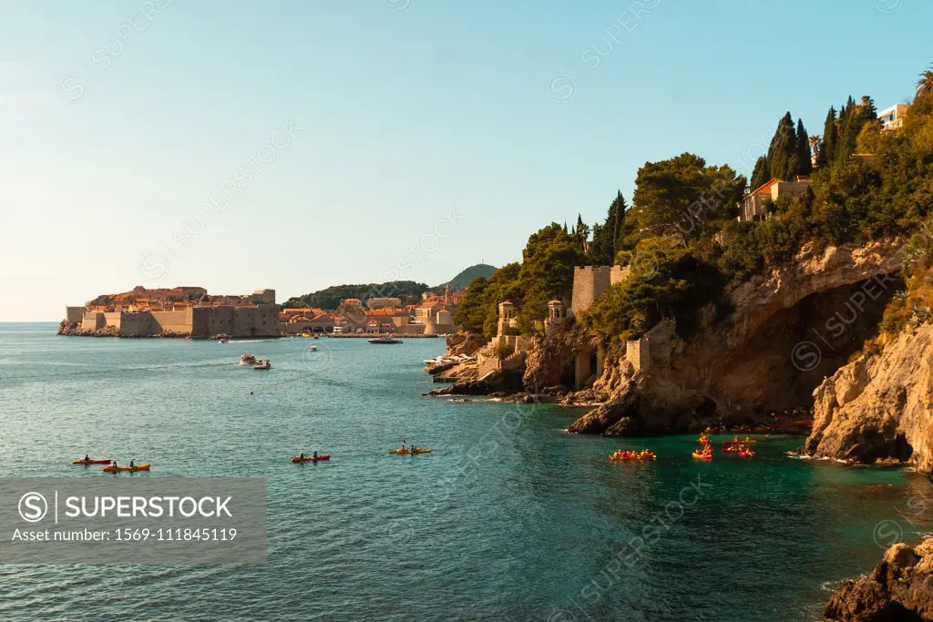 People kayaking in sea by rock formations