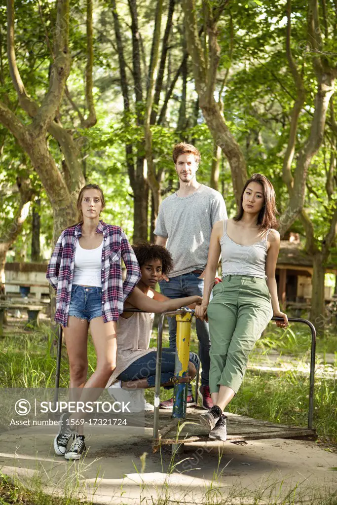 Young friends standing on old platform of merry-go-round