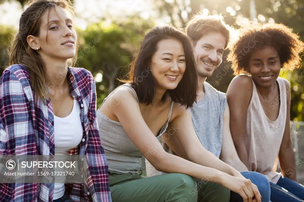 Group of young friends sitting together in park