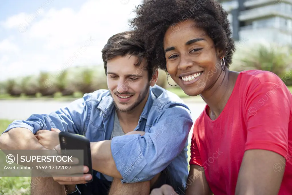 Young couple using smartphone in park