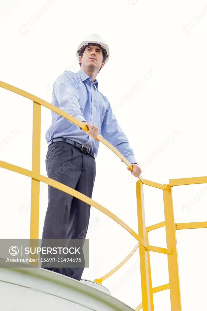 Engineer standing on top of storage tank at industrial plant