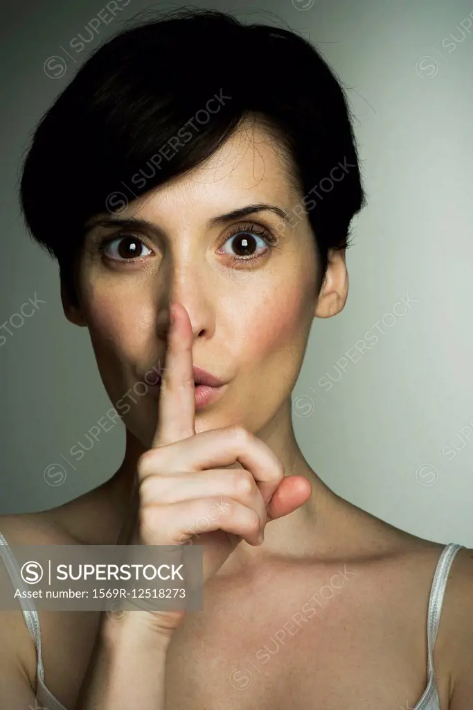 Mid-adult woman making shush gesture