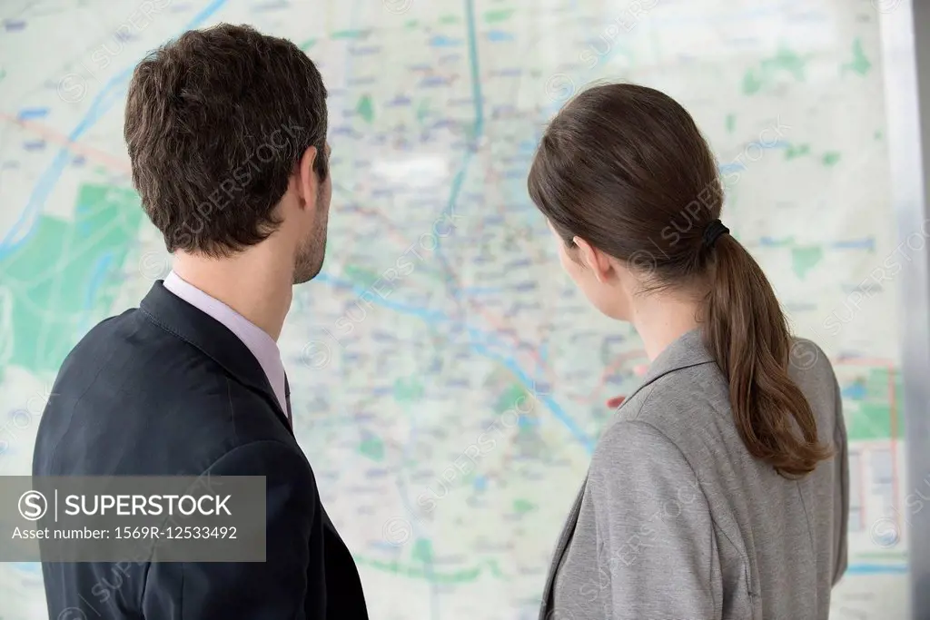 Man and woman looking at Paris metro map together