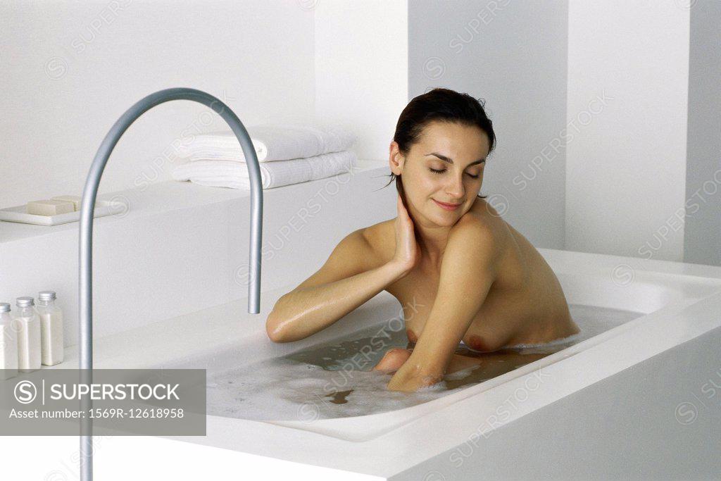 Woman sitting in bath eyes closed SuperStock