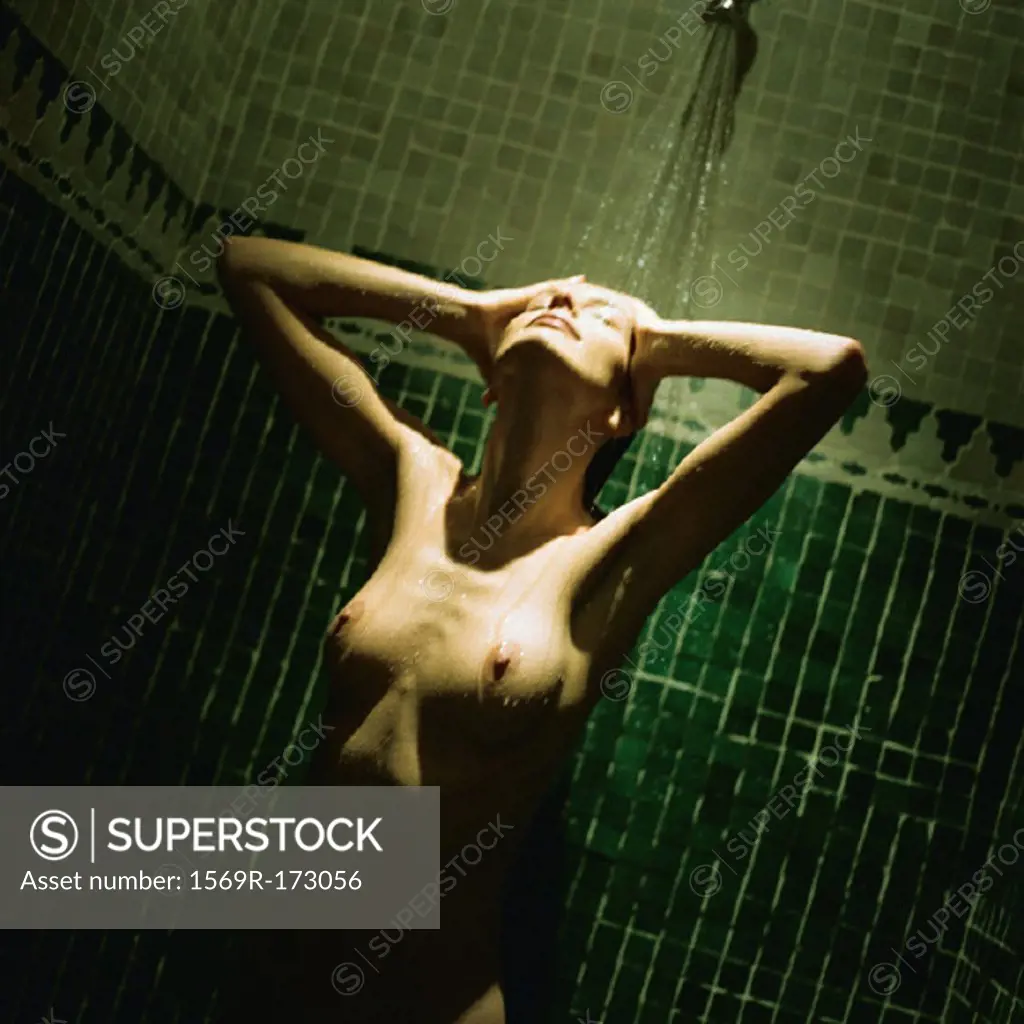 Nude woman taking shower, waist up, tilt - SuperStock