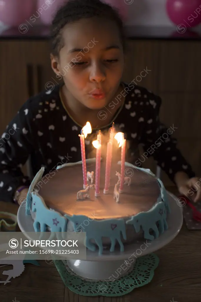 Girl blowing out candles on birthday cake