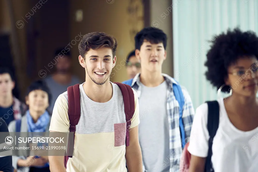 Student smiling as he walks between classes