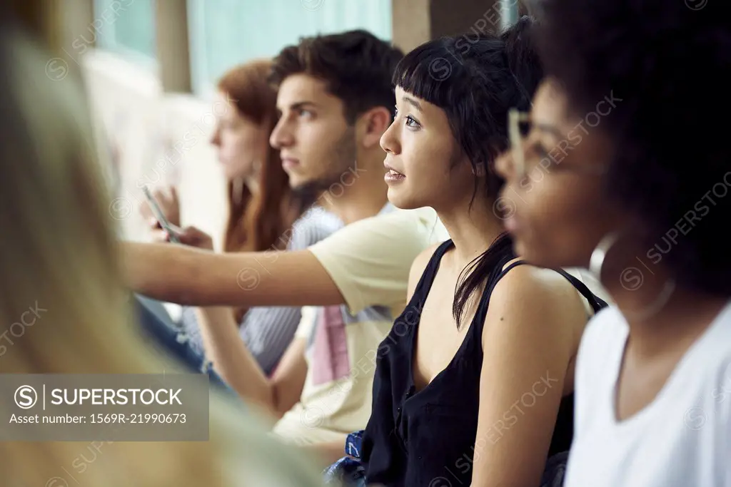 Students sitting in a row, looking up attentively