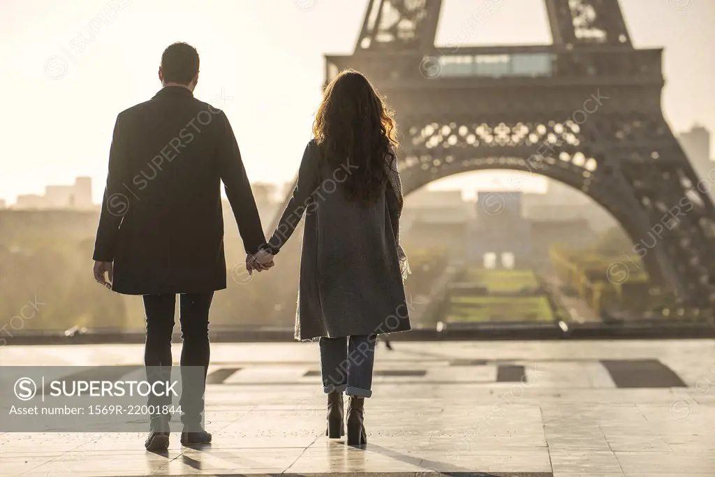 Couple holding hands near Eiffel Tower