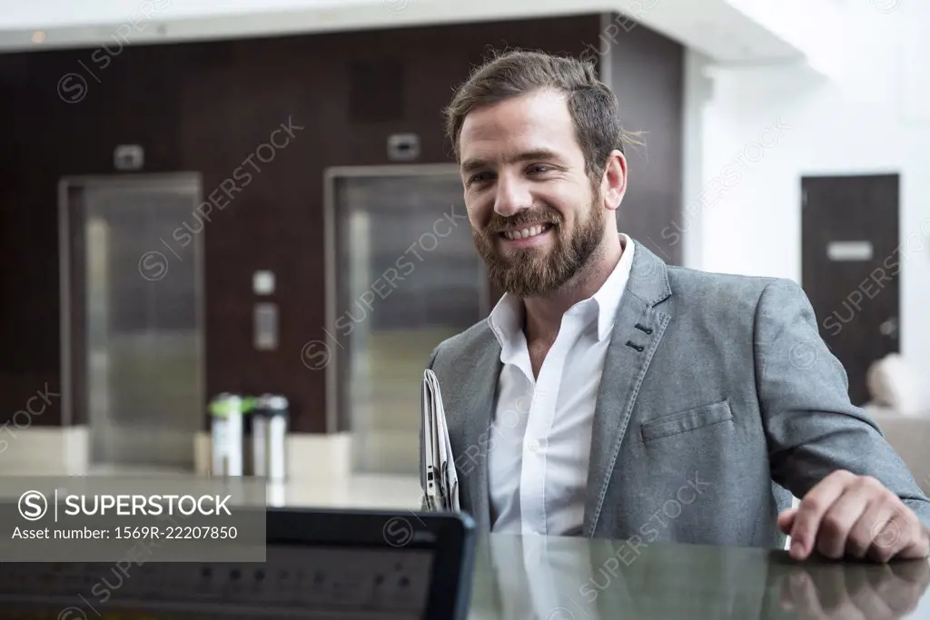 Businessman standing at hotel reception counter