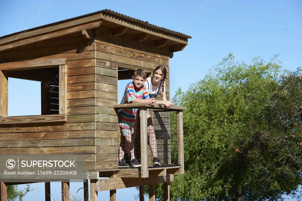 Boy and teenage girl standing in a log cabin