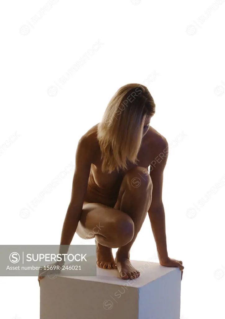 Naked woman in profile, sitting on floor - SuperStock
