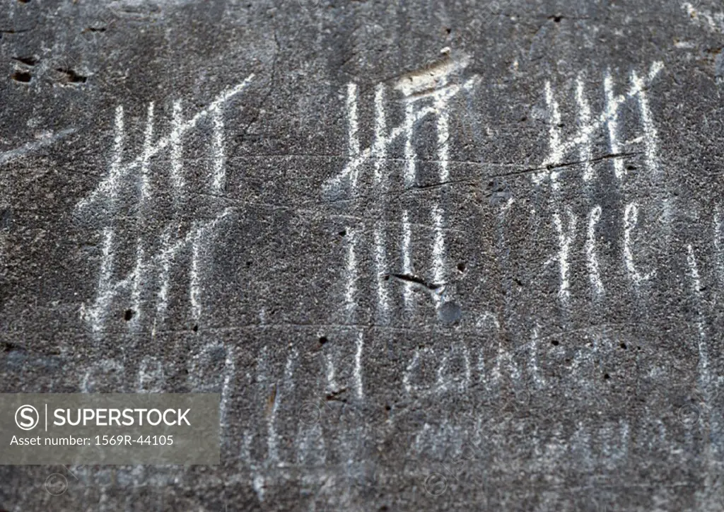 Chalk marks measuring time on wall, close-up