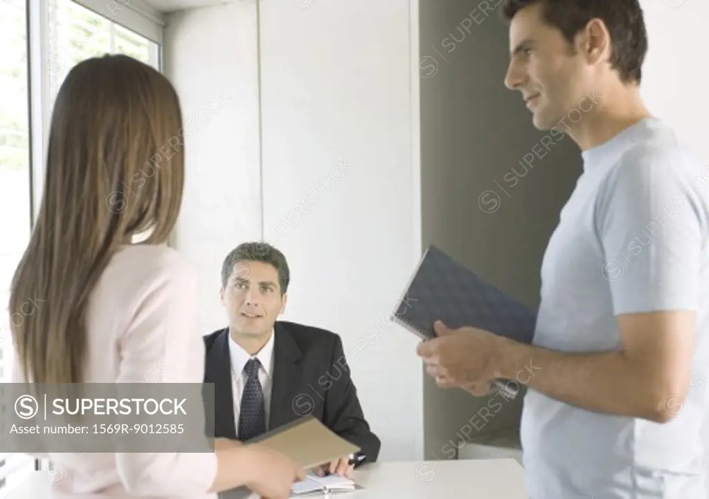 Couple speaking to businessman in office