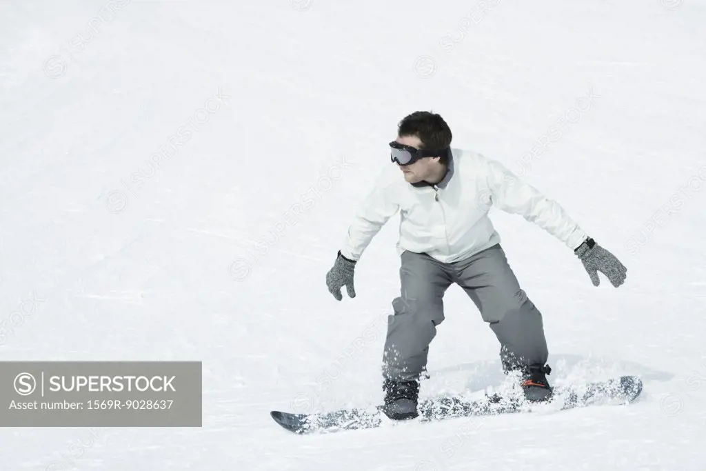 Young man snowboarding, full length