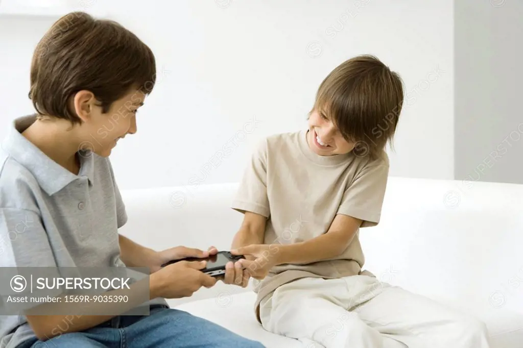 Two brothers fighting over handheld video game