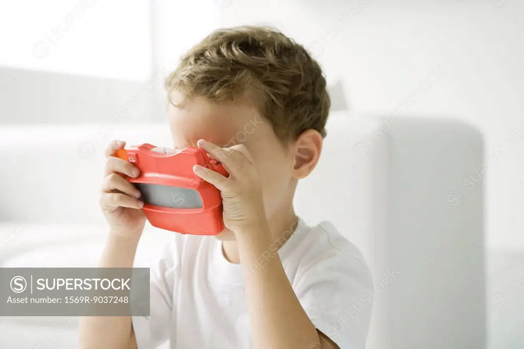 Little boy looking in toy view finder