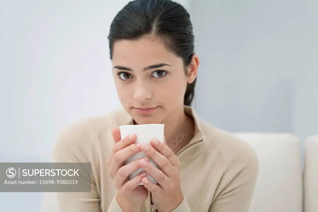 Young woman holding drink, portrait