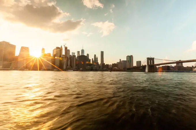 Manhattan city skyline and Brooklyn Bridge at sunset