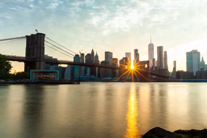 Manhattan skyline and Brooklyn Bridge at sunset