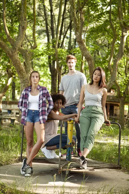 Young friends standing on old platform of merry-go-round