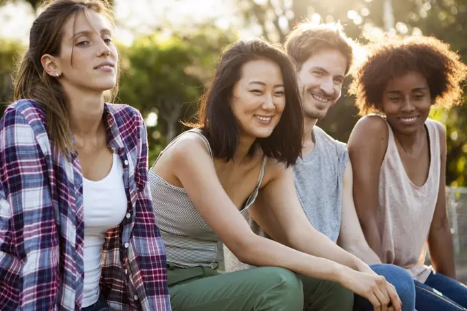 Group of young friends sitting together in park