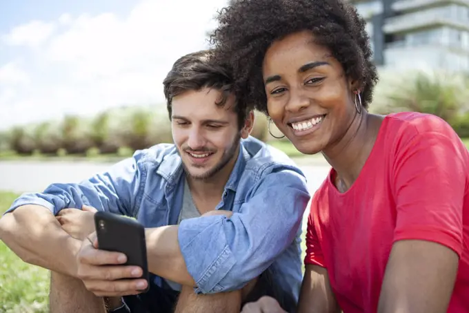 Young couple using smartphone in park