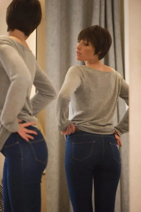 Woman trying on jeans in fitting room