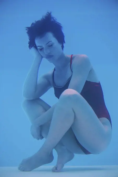 Woman soaking underwater with sad expression