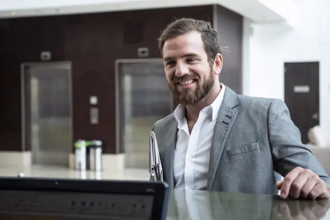 Businessman standing at hotel reception counter