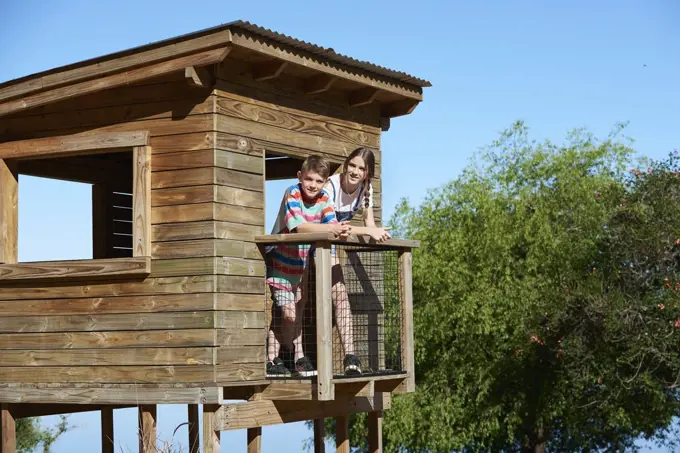 Boy and teenage girl standing in a log cabin