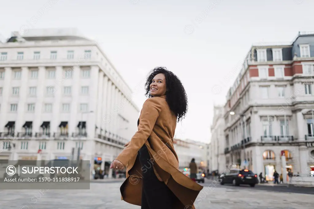 Portrait carefree young woman on urban street, Lisbon, Portugal