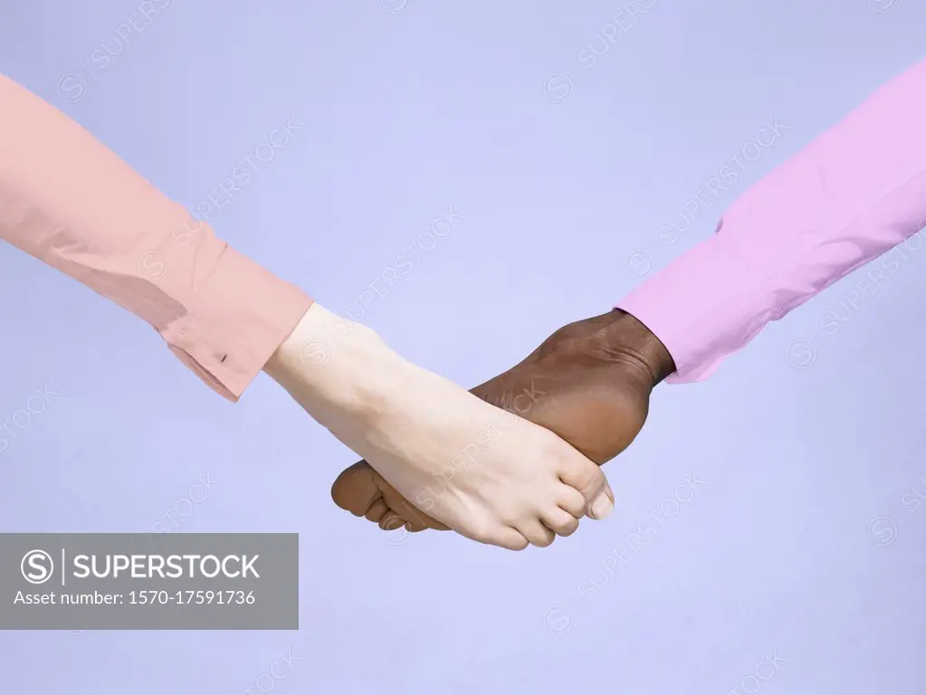 Multiethnic barefoot foot bump on purple background