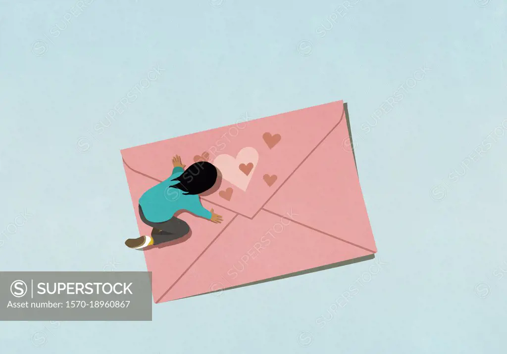 Woman kneeling over pink envelope with hearts