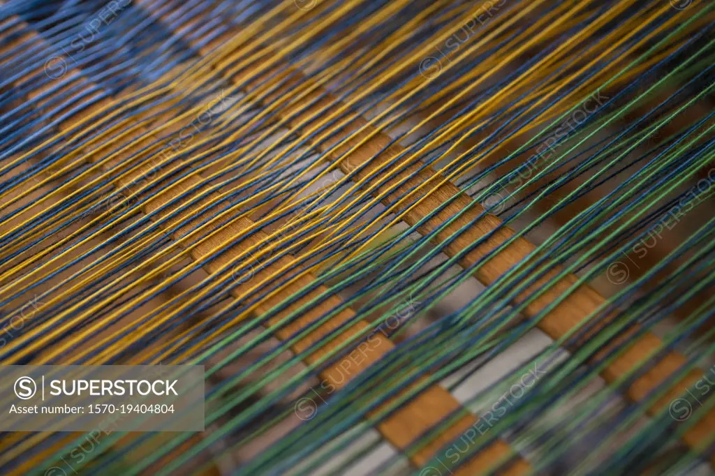 Close up green and yellow thread on loom