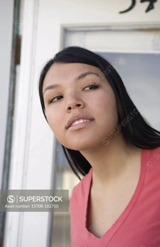 Young Native American woman standing at front door