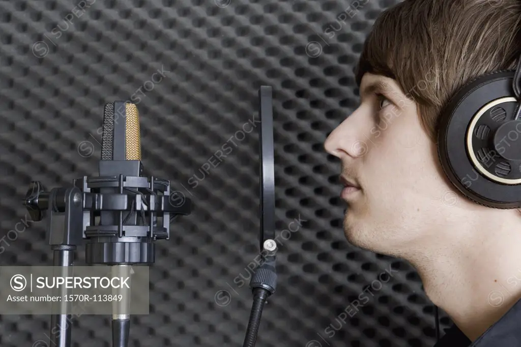 Man in sound booth of recording studio