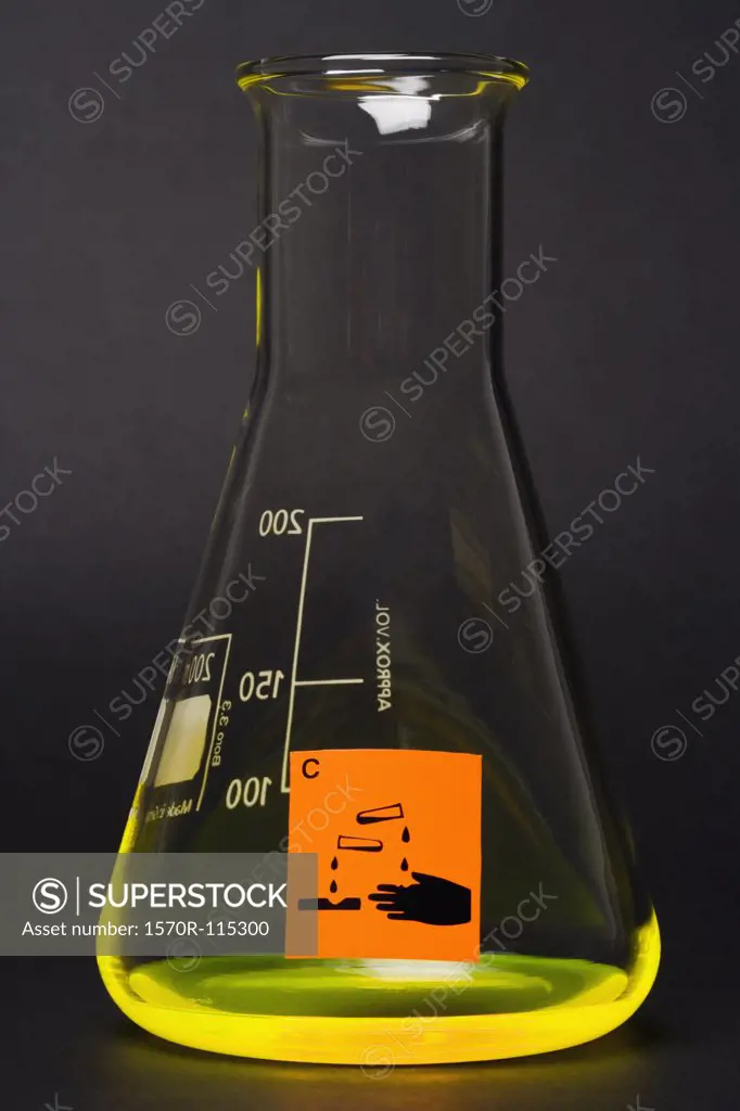 Corrosive’ label on conical flask containing yellow liquid