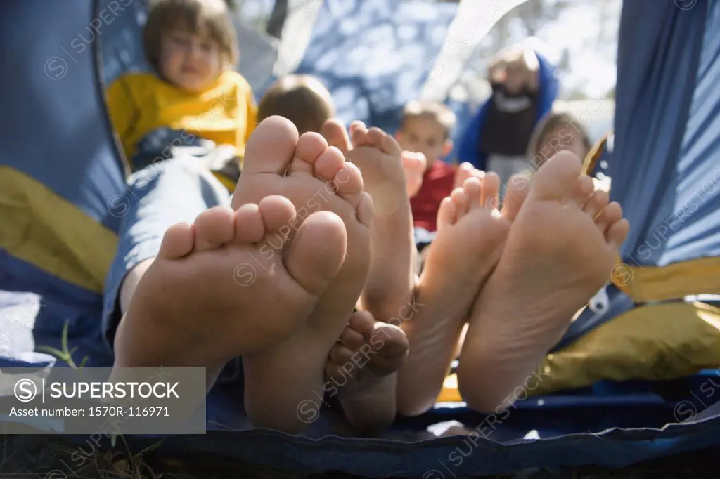 View of children's feet poking out of a tent