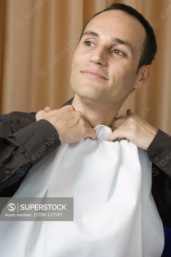 A man tucking a napkin into his shirt collar