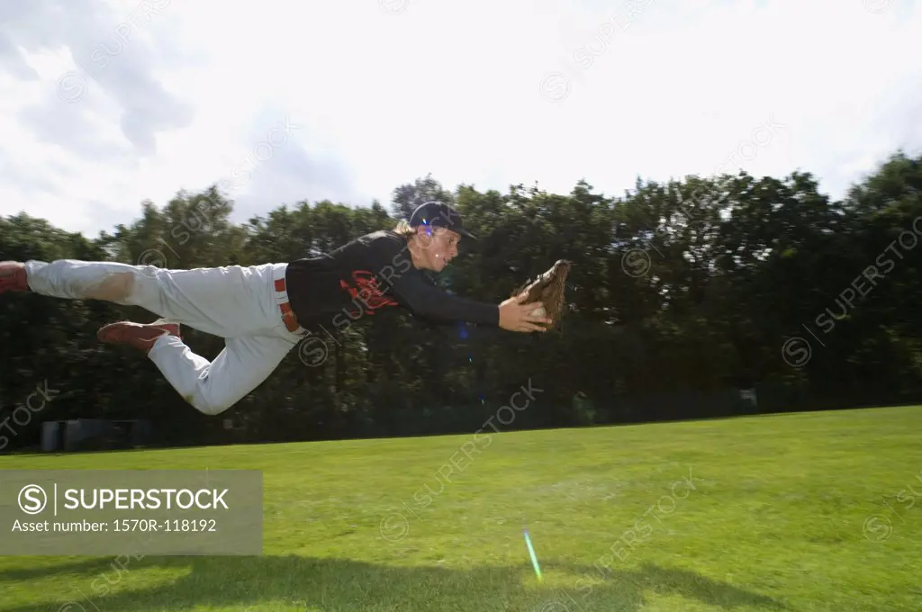 A baseball player diving to catch the ball