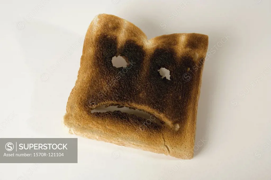 A slice of burnt toast with a sad face