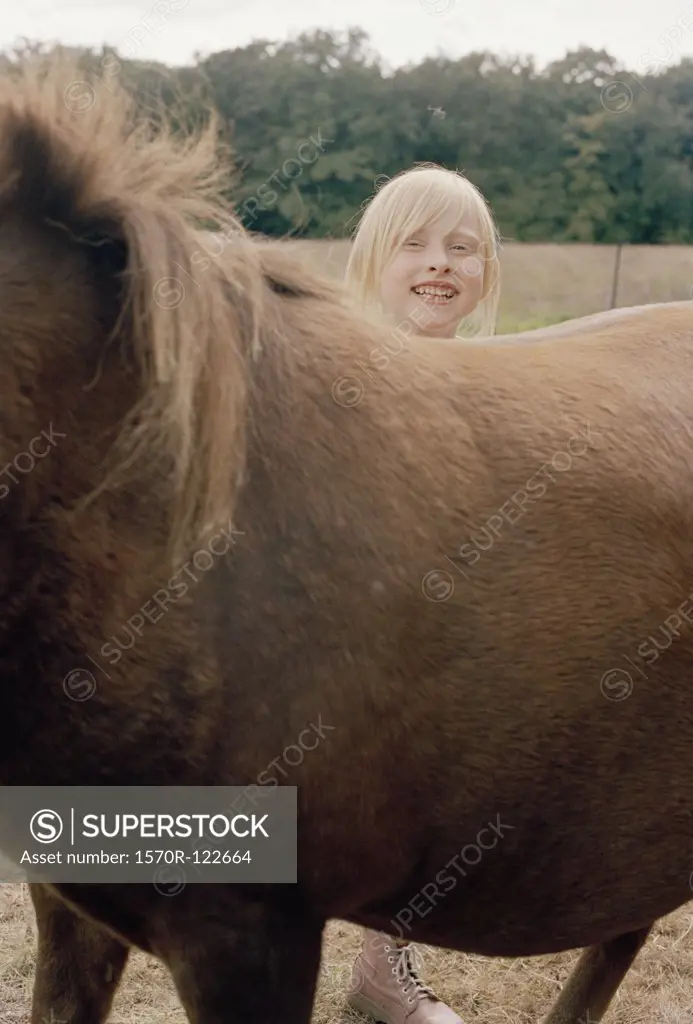 A girl standing behind a horse