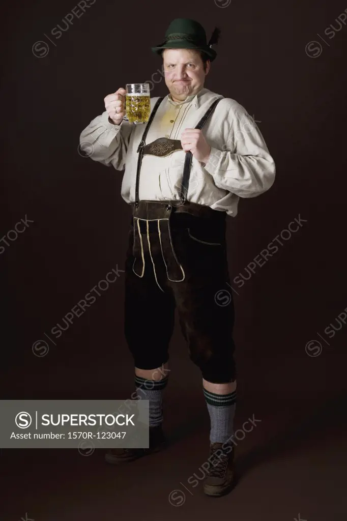 Stereotypical German man in Bavarian costume rasing a beer in toast