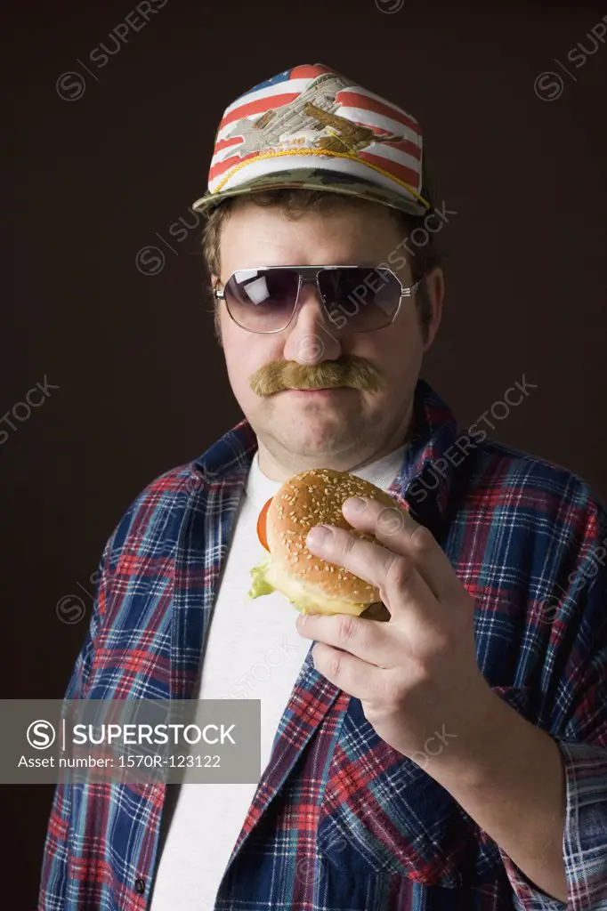 Stereotypical American man holding a hamburger