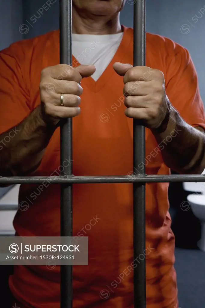 A prisoner standing behind his prison cell door