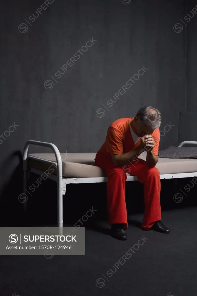 A prisoner sitting in his prison cell