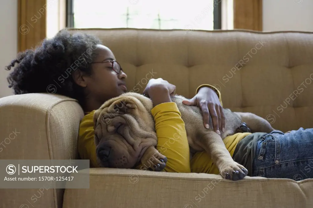 A young woman and her Shar-Pei napping on a couch